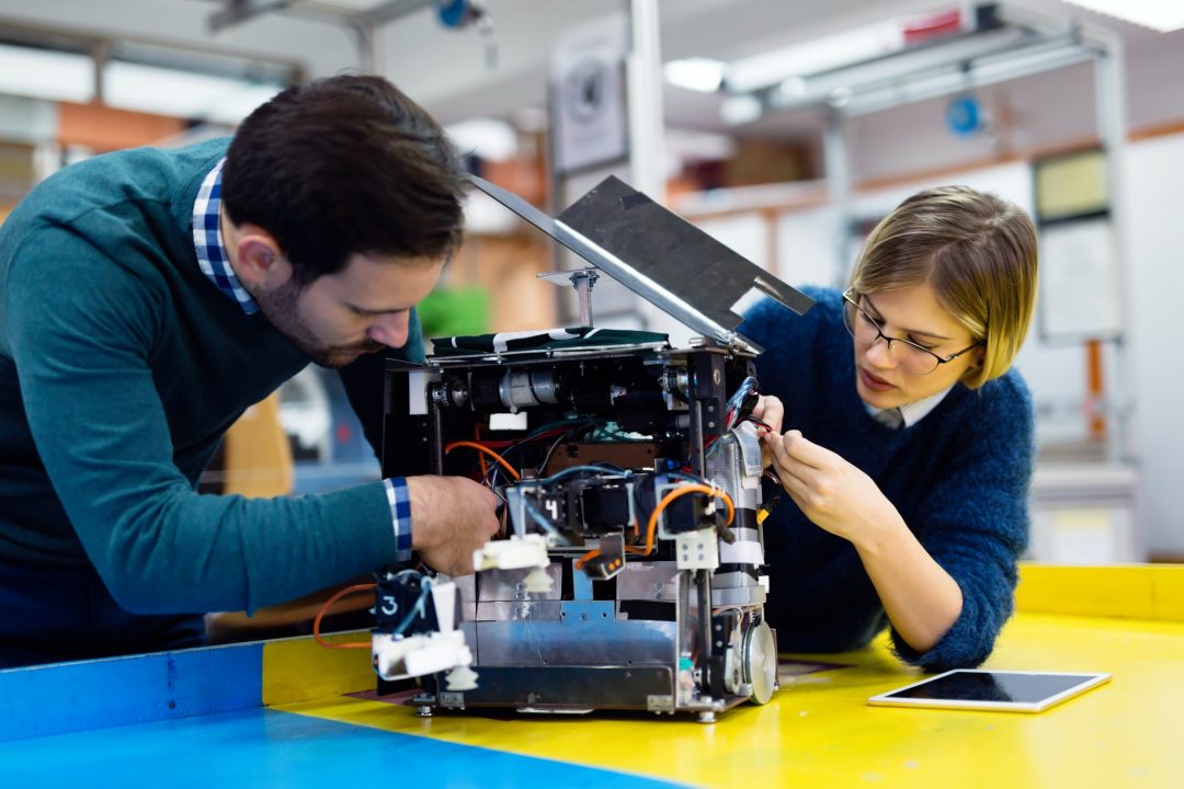 A group of enthusiastic young students engaged in preparing and programming robots for various tasks